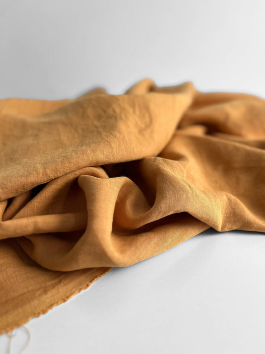 Folded orange linen fabric on a white background