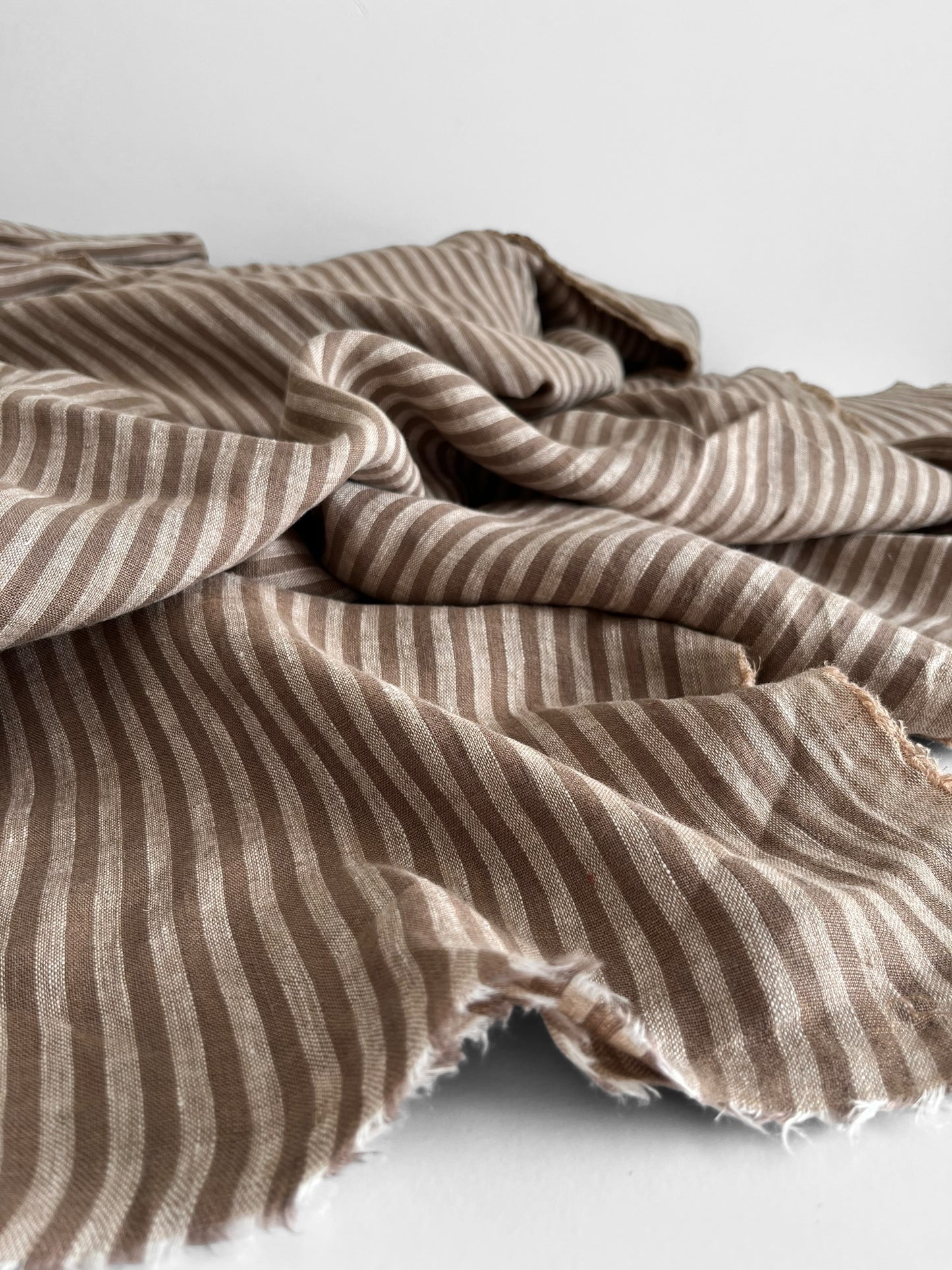 Mocha brown stripy linen fabric on a white background 