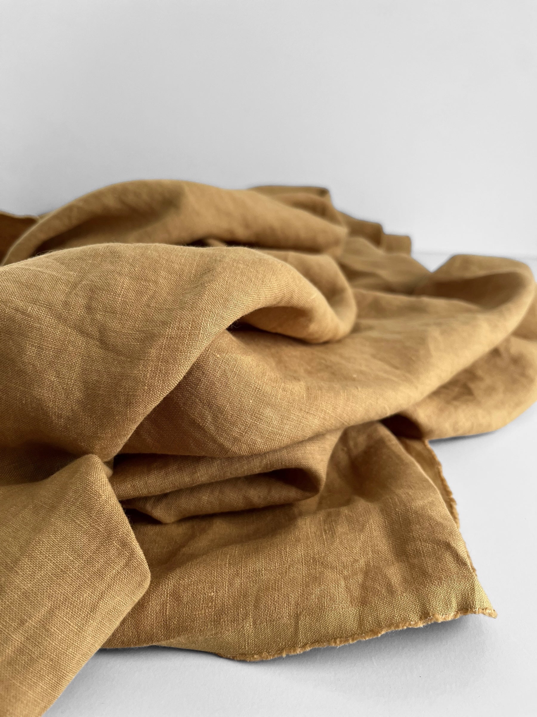 Folded mustard yellow fabric on a white background