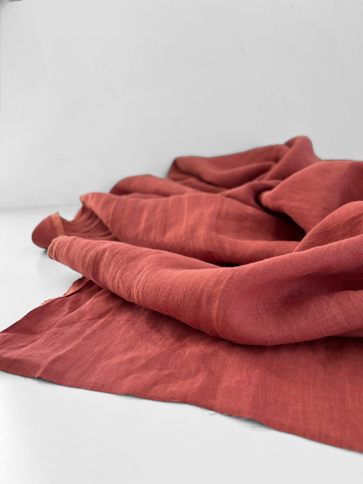 Pinkish red fabric draped over a white surface
