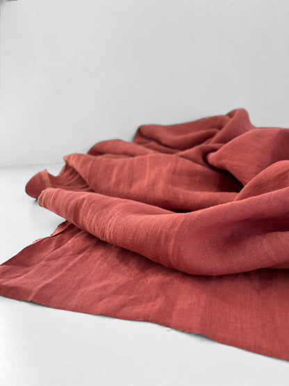 Pinkish red fabric draped over a white surface